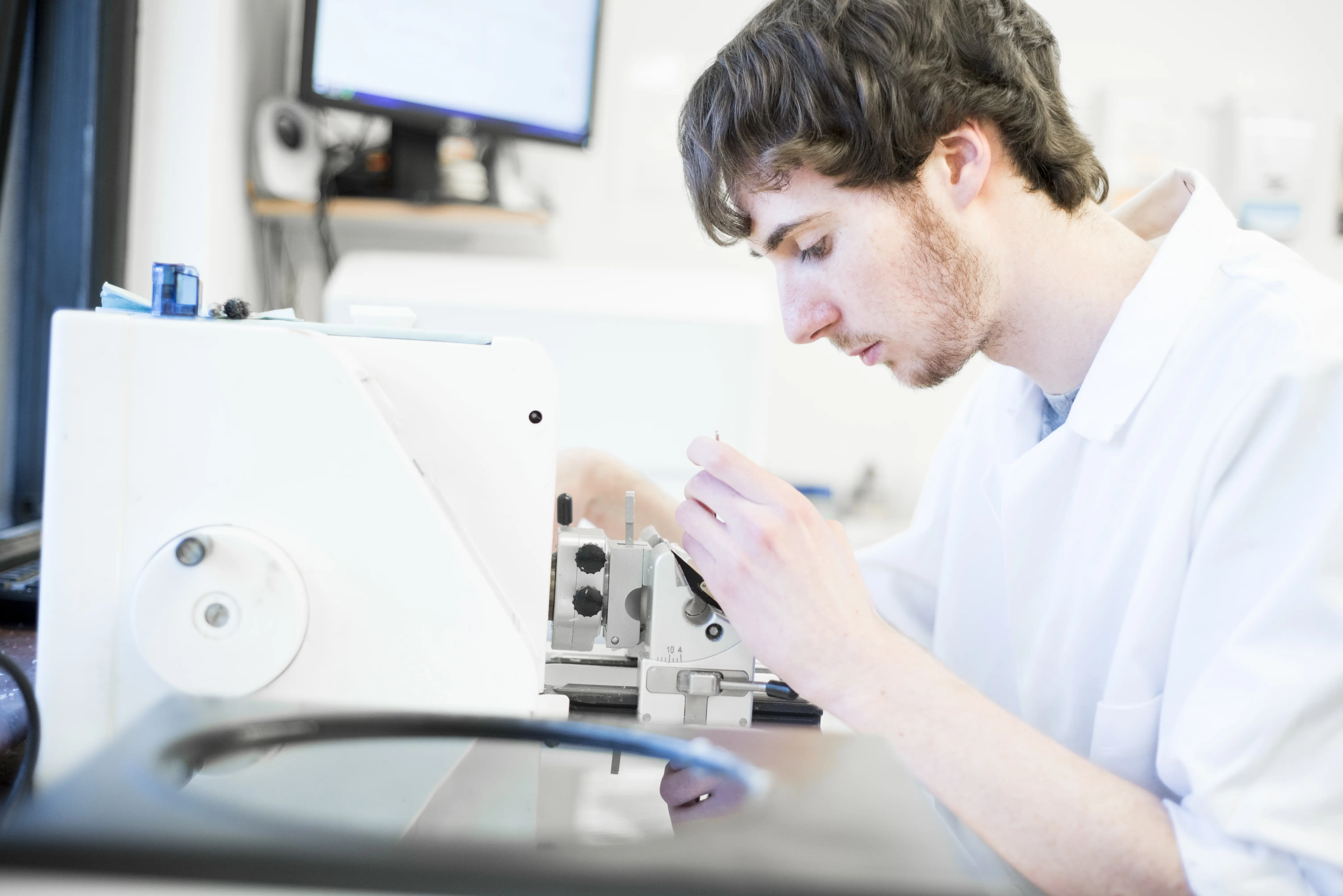 A Fishvet worker preparing thin sections of samples using a microtome, ready for microscopic analysis.