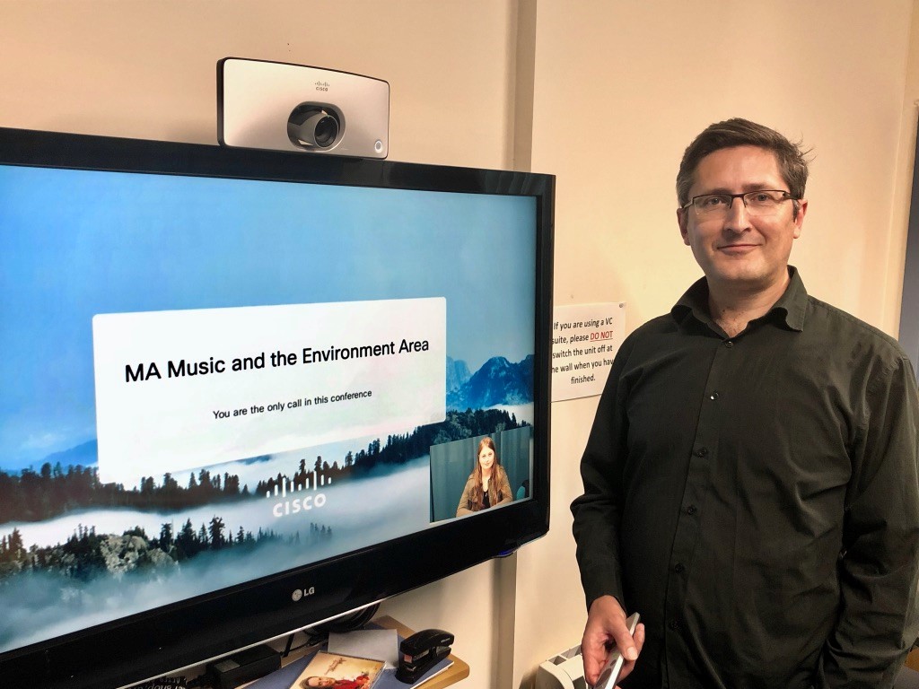 man standing by large screen