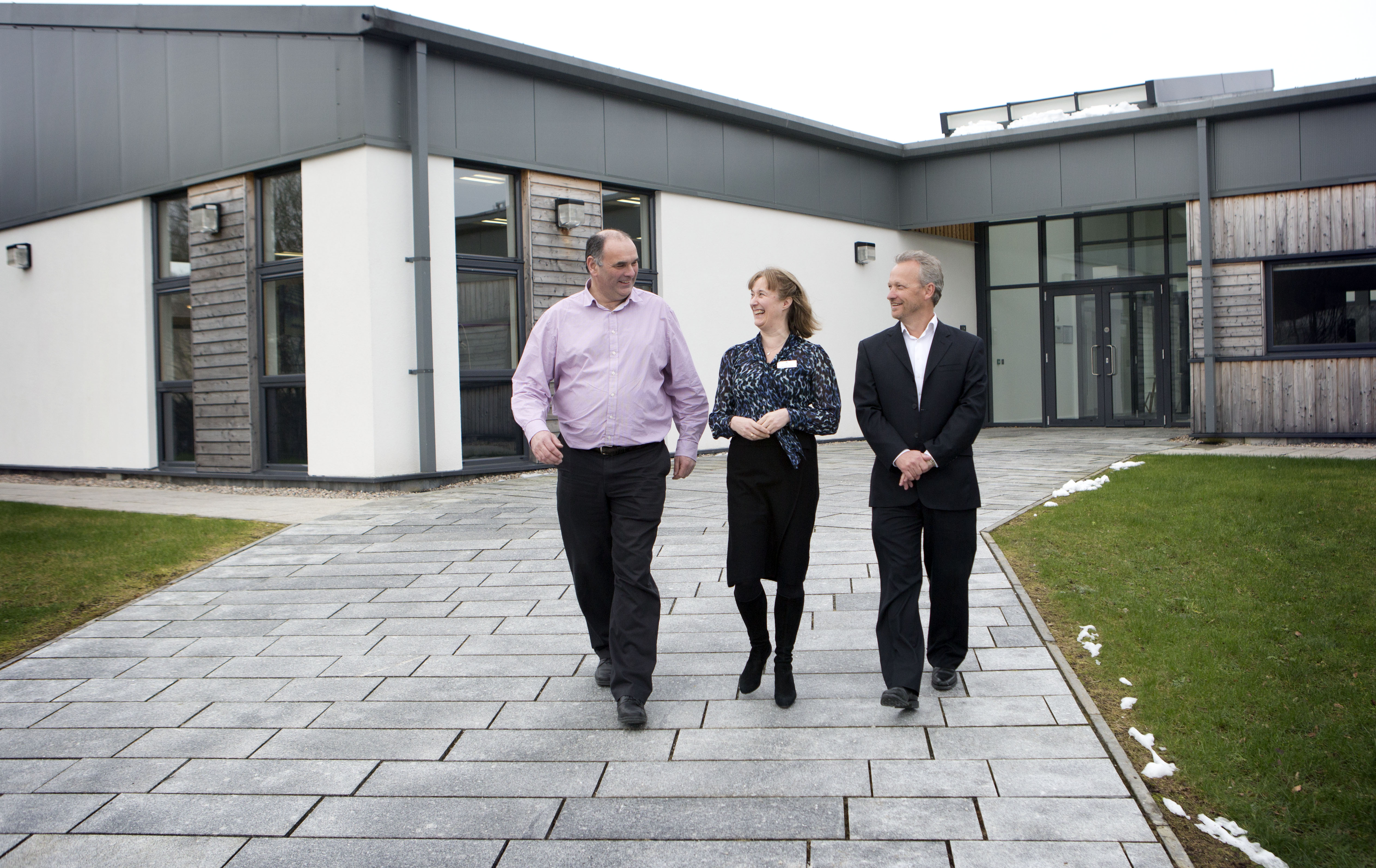 Three people walking in front of the Fairmile Building, Dunoon, Argyll