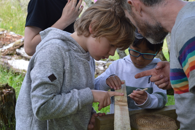 youngster looking intently at piece of wood