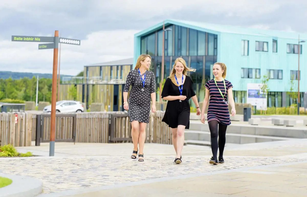 Three workers walking outside HIE headquarters on sunny day
