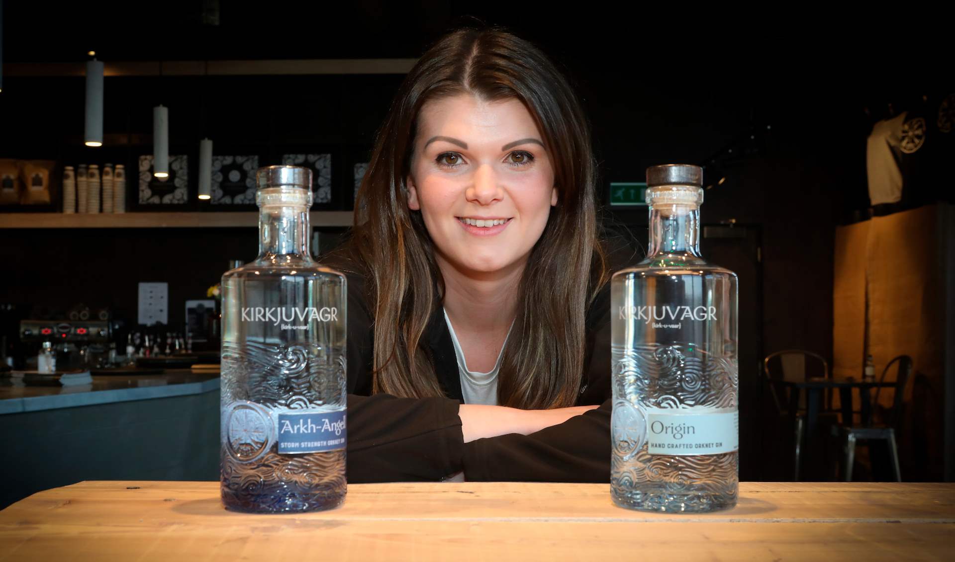 Woman in the middle of two crafted clear bottles of gin