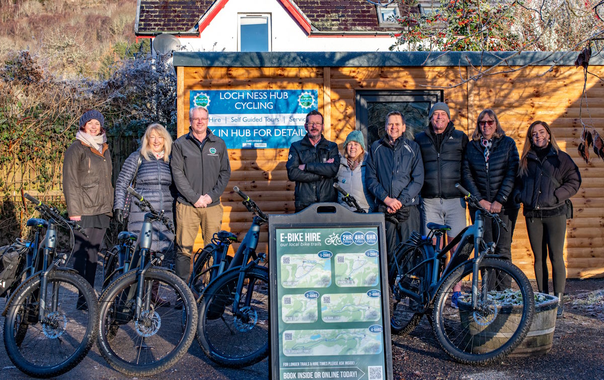 Group of people and bikes in front of the cycling hub building